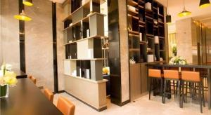 Echarm Hotel Wuhan Vanke Future Center Wulidun Metro Station في ووهان: بار في مطعم مع طاولة وكراسي