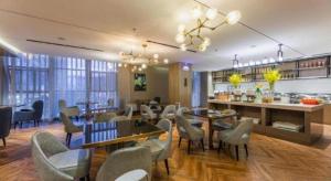 a restaurant with tables and chairs and a bar at Echarm Hotel Enshi Cultural Center Xintiandi in Enshi