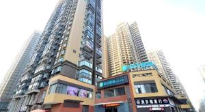 City Comfort Inn Wuhan Guanggu Textile University في ووهان: مبنى طويل أمام بعض المباني الطويلة