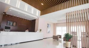 City Comfort Inn Shantou Daxue Road في شانتو: لوبي مع كونتر استقبال وشخص في الخلفية