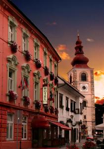 a building with a clock tower on a street at Hotel Mitra, Story Hotels in Ptuj
