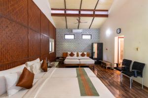 a bedroom with a large bed and a couch at Discovery Village Kabini in Antarasante