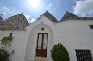 a white building with a door and two roofs at I Trulli Di Ottavio in Alberobello