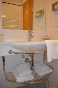 a bathroom sink with towels on a rack under it at Hotel Jäger in Vienna +46 photos
