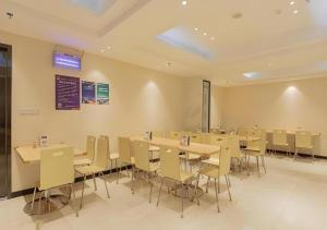 a dining room with tables and chairs in it at City Comfort Inn Liuzhou Wuxing Walking Street in Liuzhou