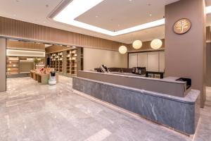 vestíbulo con mostrador de recepción y reloj en JI Hotel Shenzhen Guangming Tianhuicheng, en Bao'an
