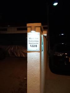 a sign on a pole in front of a bed at West Inn Colombo in Colombo
