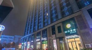 a large building with lights on in a city at night at City Comfort Inn Wuhan International Expo Center Yongwang in Wuhan