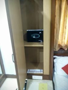 une chambre avec une armoire et une radio. dans l'établissement Strand Hotel, Colaba, à Mumbai