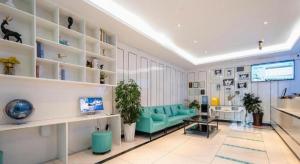 Xana Lite· Xi'an South Gate Yongningmen Subway Station في شيان: غرفة معيشة مع أريكة زرقاء ورفوف