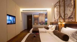 a hotel room with a large bed and a television at James Joyce Coffetel· Wuhan Wangjiawan Taojialing Metro Station in Wuhan