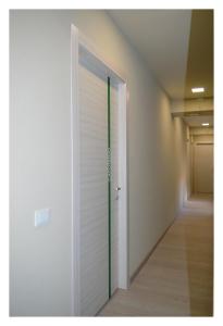 a corridor with a white door and a hallway at B&B Stazione Dittaino in Assoro