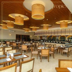 Un restaurante con mesas, sillas y luces. en The Tropics at MacArthur Park, en Palo