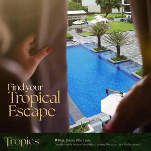 una persona mirando por una ventana a una piscina en The Tropics at MacArthur Park, en Palo