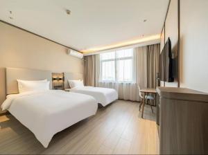 Ένα ή περισσότερα κρεβάτια σε δωμάτιο στο Hanting Hotel Shanghai Pudong Airport Nanzhu Road