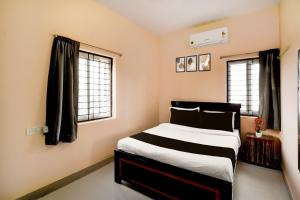 a bedroom with a bed and two windows at Super Hotel O Bharat Institute of Engineering Hyderabad Formerly Blue Petals in Hyderabad