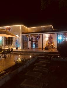 una casa con un árbol de Navidad delante de ella por la noche en Finca el origen 2025, en Roldanillo