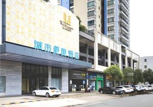 a city street with cars parked in front of a building at City Comfort Inn Foshan Sanshui Datang in Xingrenbi