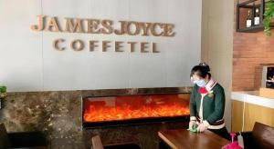 a woman wearing a face mask in front of a restaurant at James Joyce Coffetel Beijing Tongzhou Guoyuan Metro Station in Tongzhou