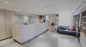 a kitchen with a counter and a couch in a room at Green Tree Inn Express Shanghai Bund Yuyuan Xiaonanmen Metro Station in Shanghai