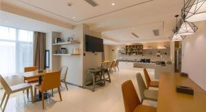 City Comfort Inn Shiyan High-speed Railway Wanda Plaza في Shiyan: غرفة طعام ومطبخ مع طاولة وكراسي