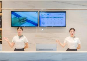 a woman standing in front of a counter with her hands at City Comfort Inn Kunshan Development Zone Penglang Xinxing Middle Road in Penglang