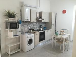 a kitchen with a washing machine and a table at Casa Cristina e Mauro in La Spezia
