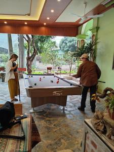 a man and a woman standing next to a pool table at Sun Mountain Hostel in Nguyên Ngoại