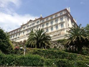 ein großes Gebäude mit Palmen davor in der Unterkunft Casinha Nº461 in Vila Praia de Âncora