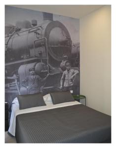 1 dormitorio con 1 cama y un mural de tren en B&B Stazione Dittaino, en Assoro