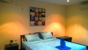 a bedroom with a bed and a painting on the wall at Baan-kawkaew-kata in Ban Karon