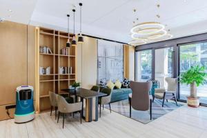 a living room with a couch and a table and chairs at City Comfort Inn Yunfu Xinxing Juncheng Plaza in Xinxing