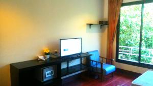 a room with a desk with a computer and a window at Baan-kawkaew-kata in Ban Karon