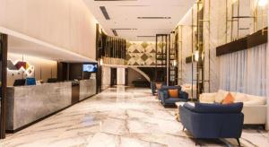 a lobby of a hotel with couches and a television at Borrman Hotel Yunfu Xinxing County Bus Station in Xinxing