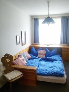 a bedroom with a bed with blue sheets and a window at Ferienwohnung Heidi in Flachau