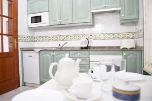 a kitchen with green cabinets and white dishes on a counter at Villas Bocaina Beach in Puerto del Carmen