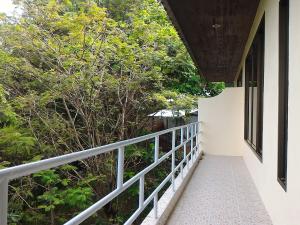 a balcony of a house with trees in the background at Baan-kawkaew-kata in Ban Karon +5 photos