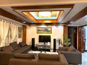 a living room with a couch and a television at Florabells Guest House - Batanes in Basco