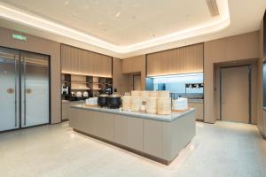 Eine Küche mit einer Arbeitsfläche voller Teller in der Unterkunft JI Hotel Shanghai Jinshan Industrial Zone in Jinshan