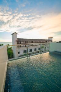 un bâtiment avec une piscine d'eau devant lui dans l'établissement Emerald Resort Hikkaduwa, à Hikkaduwa