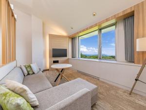 a living room with a couch and a large window at Kiyosato Kogen Resort in Hokuto +2 photos