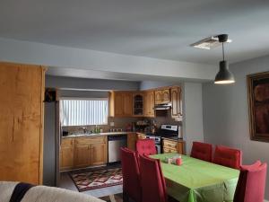 cocina con mesa verde y sillas rojas en Spacious home near LAX, en Hawthorne