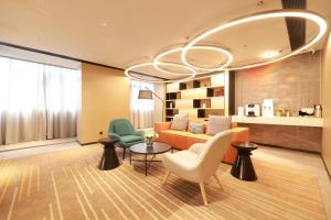 ein Wohnzimmer mit einer Couch und Stühlen und einem Kronleuchter in der Unterkunft Ni Hao in Houshayu