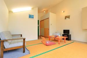 a living room with a chair and a table at 秘湯花文 in Myoko