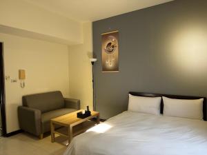 a hotel room with a bed and a chair at 台中向日葵 in Taichung