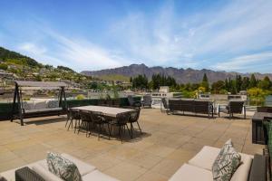 THE SHOTOVER Central Queenstown Luxury في كوينزتاون: فناء به طاولة وكراسي وجبال