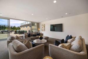 THE SHOTOVER Central Queenstown Luxury في كوينزتاون: غرفة معيشة مع أرائك وتلفزيون بشاشة مسطحة +31 صورة