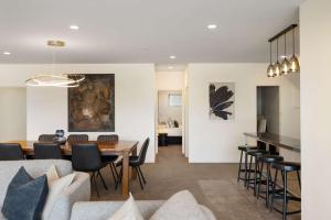 THE SHOTOVER Central Queenstown Luxury في كوينزتاون: غرفة معيشة وغرفة طعام مع طاولة وكراسي