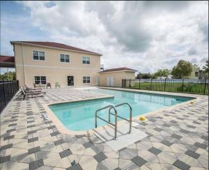 a swimming pool in front of a house at Green Palms Extended Stay in Kissimmee
