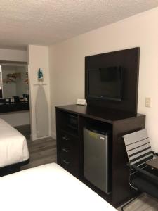 Zimmer mit einem Flachbild-TV und einem Bett in der Unterkunft Green Palms Extended Stay in Kissimmee